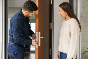 Chaveiro abrindo uma porta com ferramentas especializadas.